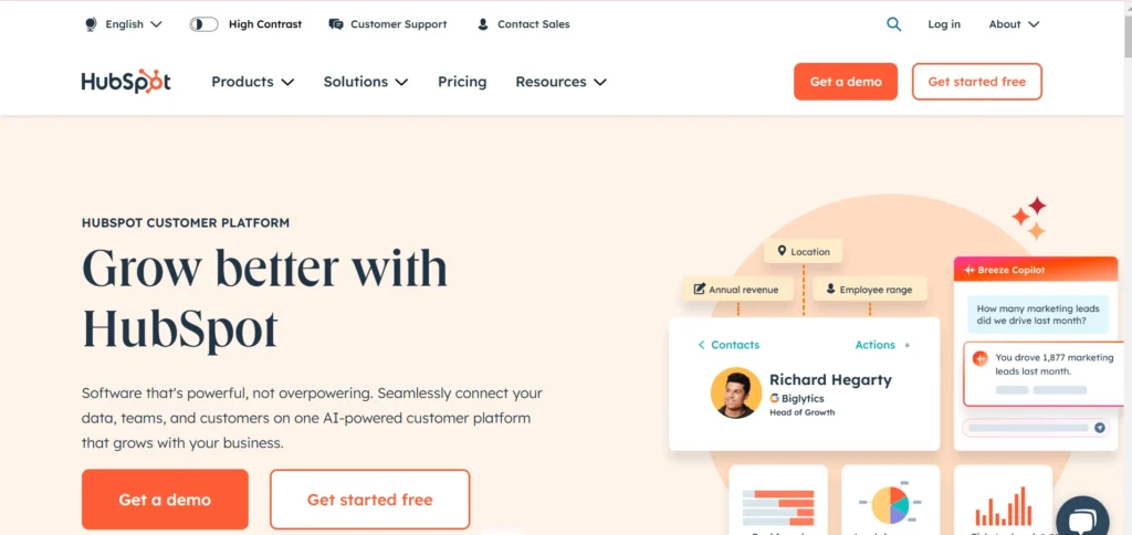 HubSpot homepage showcasing the tagline 'Grow better with HubSpot' along with two prominent call-to-action buttons, 'Get a demo' and 'Get started free.' The page highlights features of its AI-powered customer platform, including insights like location, annual revenue, and employee range. A mockup of a Breeze Copilot AI assistant is displayed, providing marketing lead data.